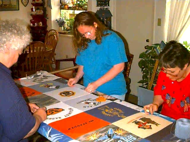 Bonnie, Clara, & Jennye tying a quilt